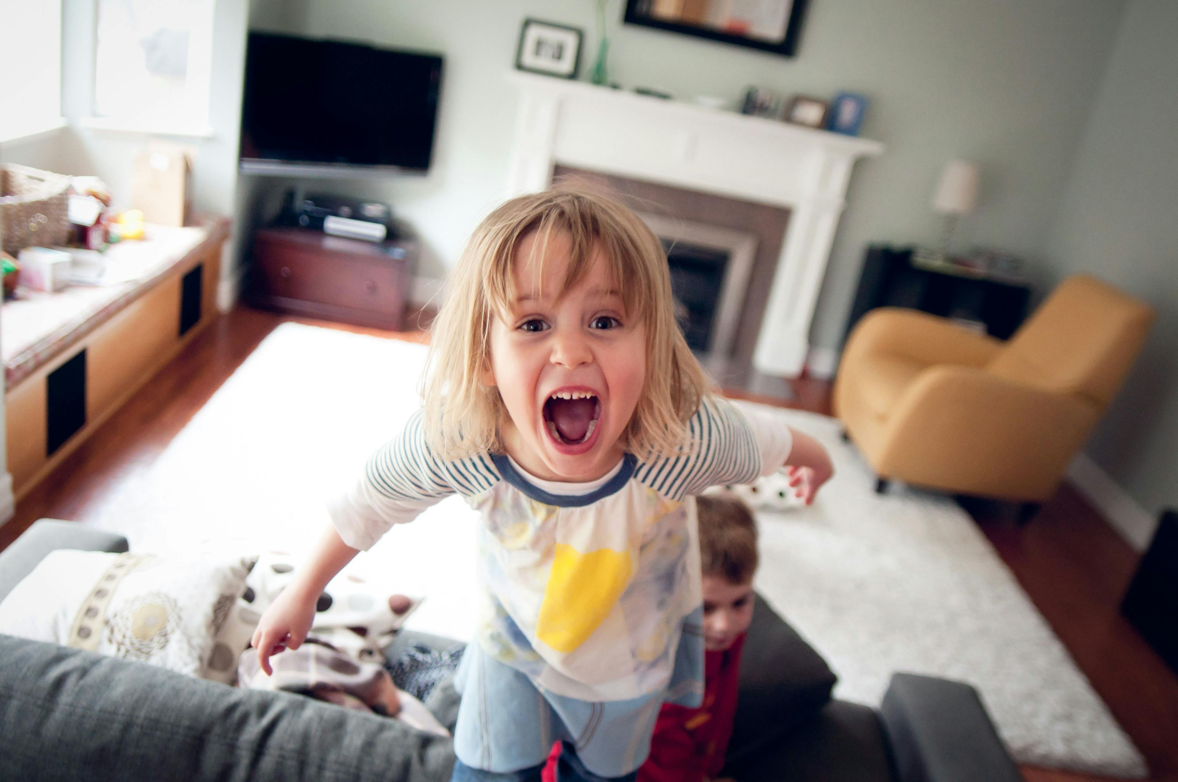 A young kid screams on a couch