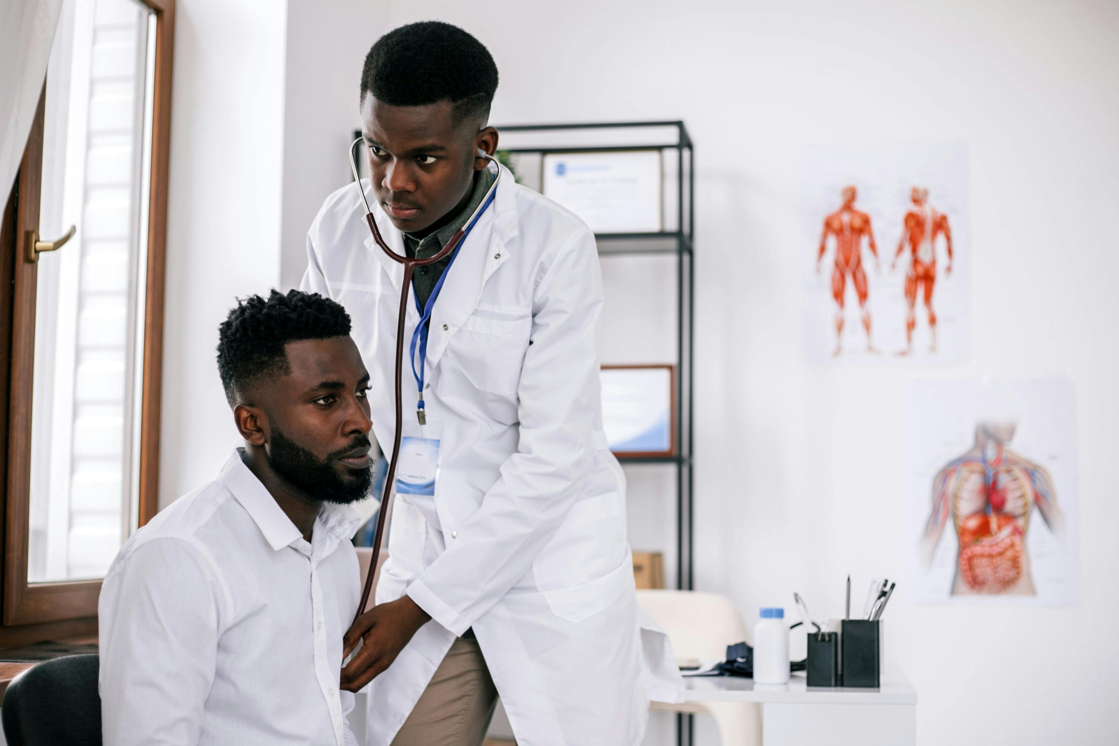 A Black doctor treats a Black patient
